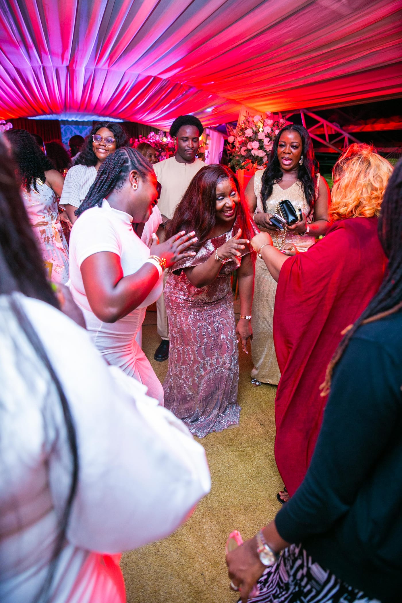 Guests dancing together under red and pink draped lighting at Kaine Diete-Spiff’s fiftieth birthday